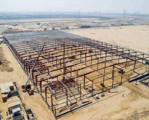 Aerial view of a large steel-framed warehouse under construction for the Emtelle project
