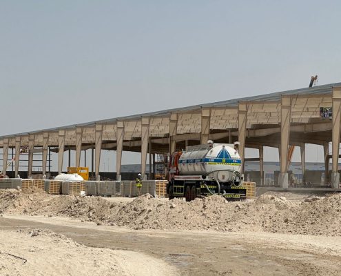 Long exterior view of a concrete and steel industrial building under construction