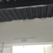 Dark fire retardant coating applied along a ceiling edge above a corridor exit
