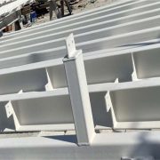 Steel I-beam sections coated with white solvent-based intumescent fireproofing