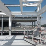 Multi-story concrete and steel building frame under construction with passive fire protection measures
