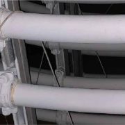 White protective coating applied to cable conduits and trunking in an industrial ceiling